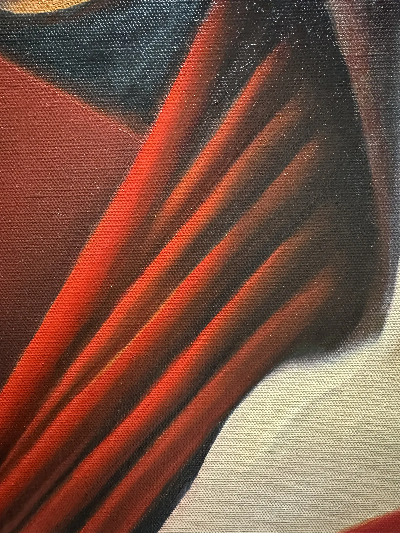 A detail of the red fabric with visible canvas during the layered colour work